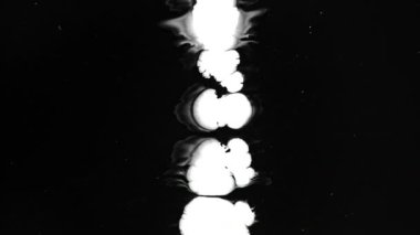 Islak siyah ekran arka plan üzerinde beyaz mürekkep damlaları