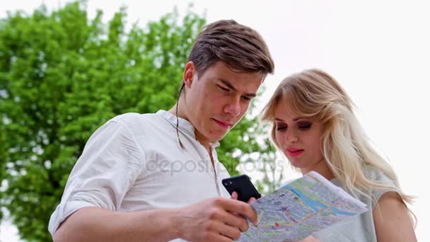 Молода пара використовує мобільний телефон на відкритому повітрі — стокове відео
