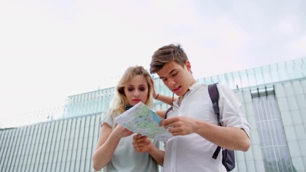 Ett ungt par med en mobiltelefon-utomhus — Stockvideo