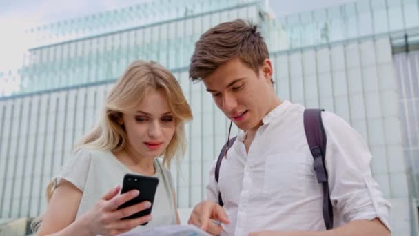 Um casal jovem usando um telefone celular ao ar livre — Vídeo de Stock