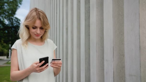 Μια κυρία χρησιμοποιώντας ένα κινητό τηλέφωνο σε εξωτερικούς χώρους — Αρχείο Βίντεο