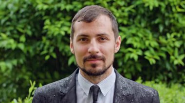 Genç adam yağmurda ayakta sakallı