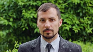 Genç adam yağmurda ayakta sakallı