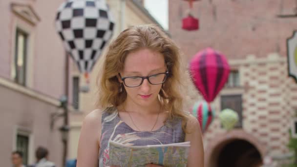 A Beautiful Redhead Tourist Using a Map Outdoors — Stock Video