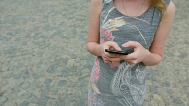 Девушка, пользующаяся мобильным телефоном на улице — стоковое видео