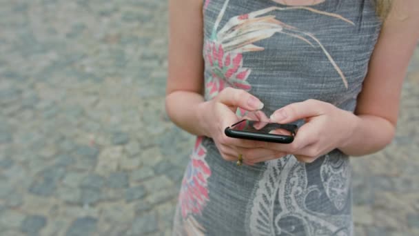 Una joven usando un teléfono móvil al aire libre — Vídeo de stock