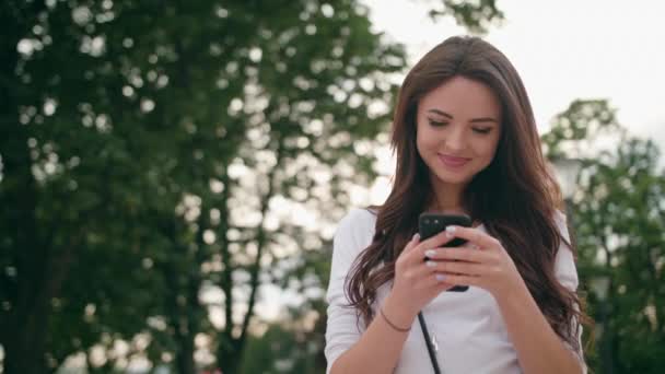 Красивая брюнетка с помощью мобильного телефона на открытом воздухе — стоковое видео