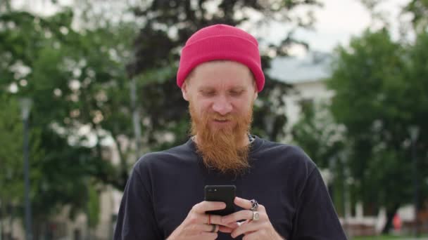 Readhead Hipster in med en Smartfone i Hand — Stockvideo