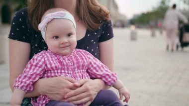 Bir güzel esmer tutan bir bebek diz