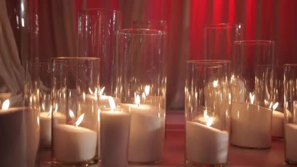 Kaarsen in glas op de verdieping met witte stof — Stockvideo