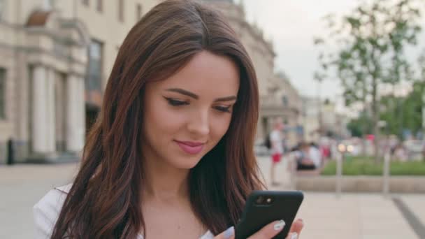 Sebuah Brunette Indah Menggunakan ponsel luar ruangan — Stok Video