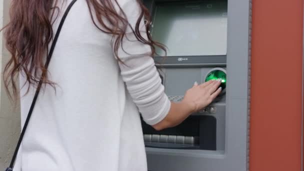 Jovem de cabelos escuros na frente do ATM — Vídeo de Stock