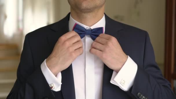 Man herstelt ' Bow-tie op een nek en knoppen jas — Stockvideo