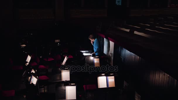 Dirigent in een orkestbak bestudeert bladmuziek — Stockvideo