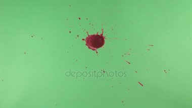 Kırmızı mürekkep sıçramak yeşil ekran arka planı üzerinde
