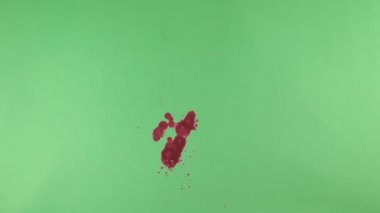 Kırmızı mürekkep sıçramak yeşil ekran arka planı üzerinde