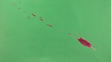 Kırmızı mürekkep sıçramak yeşil ekran arka planı üzerinde