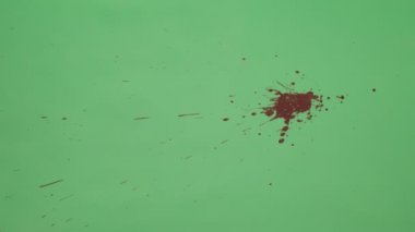 Kırmızı mürekkep sıçramak yeşil ekran arka planı üzerinde