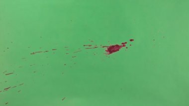 Kırmızı mürekkep sıçramak yeşil ekran arka planı üzerinde