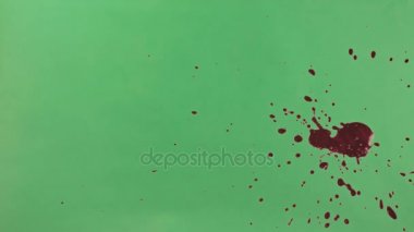 Kırmızı mürekkep sıçramak yeşil ekran arka planı üzerinde