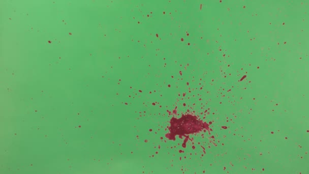 Salpicadura de tinta roja sobre fondo de pantalla verde — Vídeo de stock