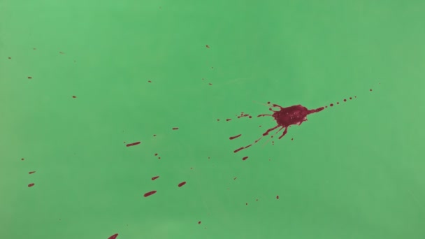 Éclaboussure d'encre rouge sur fond d'écran vert 
