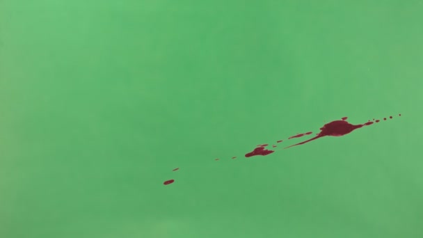 Salpicadura de tinta roja sobre fondo de pantalla verde — Vídeos de Stock