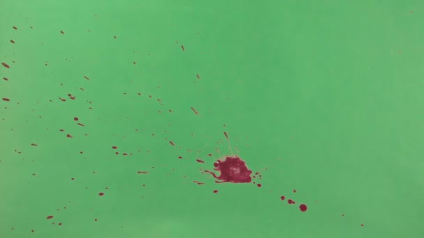 Éclaboussure d'encre rouge sur fond d'écran vert 