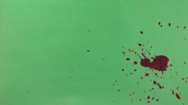 Éclaboussure d'encre rouge sur fond d'écran vert 