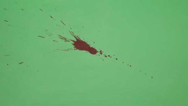 Salpicadura de tinta roja sobre fondo de pantalla verde — Vídeos de Stock