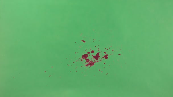 Éclaboussure d'encre rouge sur fond d'écran vert 