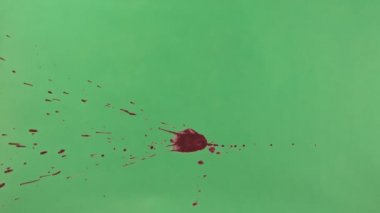 Kırmızı mürekkep sıçramak yeşil ekran arka planı üzerinde