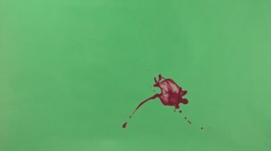 Kırmızı mürekkep sıçramak yeşil ekran arka planı üzerinde