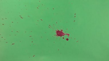 Kırmızı mürekkep sıçramak yeşil ekran arka planı üzerinde