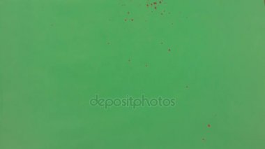 Kırmızı mürekkep yeşil ekran arka plan üzerinde serpilir