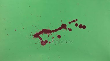 Kırmızı mürekkep sıçramak yeşil ekran arka planı üzerinde