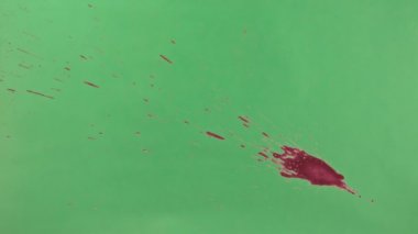 Kırmızı mürekkep sıçramak yeşil ekran arka planı üzerinde