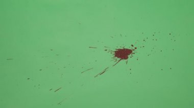 Kırmızı mürekkep sıçramak yeşil ekran arka planı üzerinde