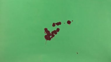 Kırmızı mürekkep sıçramak yeşil ekran arka planı üzerinde