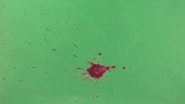 Kırmızı mürekkep sıçramak yeşil ekran arka planı üzerinde