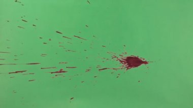 Kırmızı mürekkep sıçramak yeşil ekran arka planı üzerinde