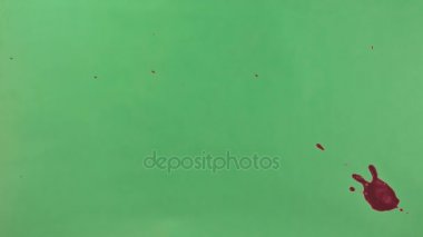Kırmızı mürekkep sıçramak yeşil ekran arka planı üzerinde