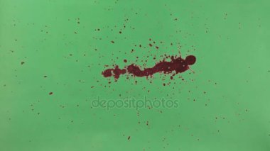 Kırmızı mürekkep sıçramak yeşil ekran arka planı üzerinde