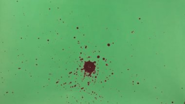 Kırmızı mürekkep sıçramak yeşil ekran arka planı üzerinde