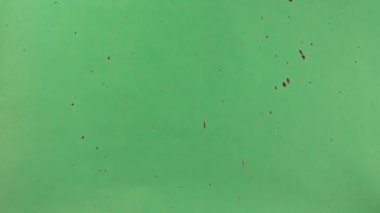 Kırmızı mürekkep yeşil ekran arka plan üzerinde serpilir