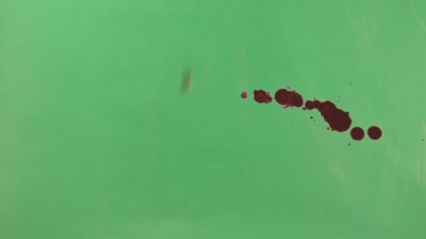 Éclaboussure d'encre rouge sur fond d'écran vert 