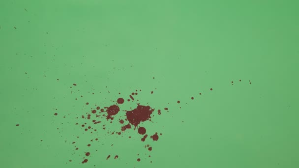 Éclaboussure d'encre rouge sur fond d'écran vert 