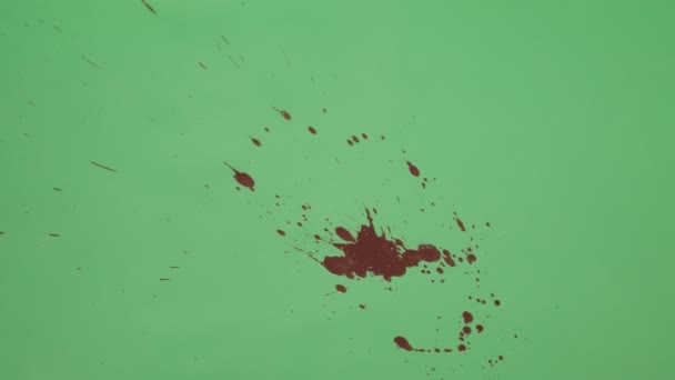 Salpicadura de tinta roja sobre fondo de pantalla verde — Vídeos de Stock