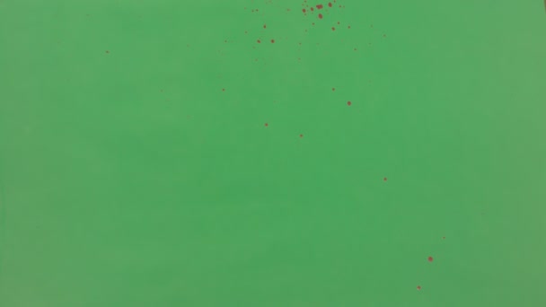 Encre rouge saupoudré sur fond d'écran vert 