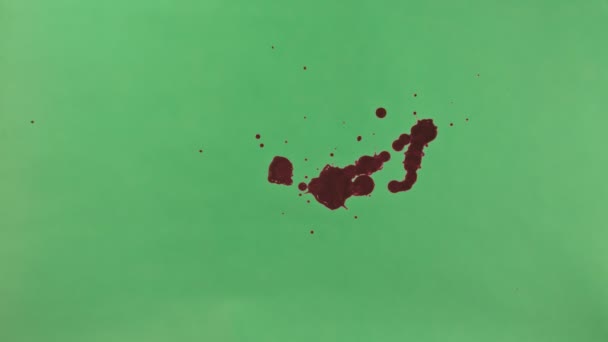 Éclaboussure d'encre rouge sur fond d'écran vert 